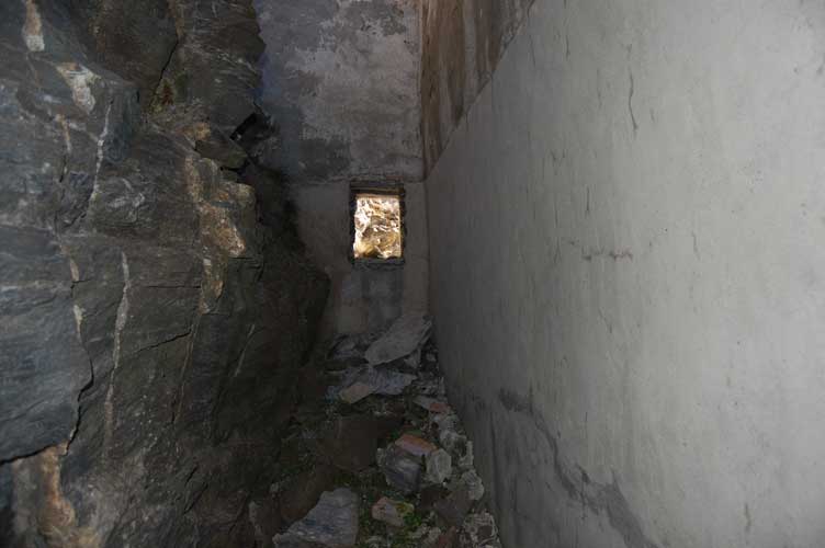 L'interno dell'intercapedine.A sx la parete rocciosa e a dx la parete in muratura del fabbricato.Di fronte la finestrella sul lato E
