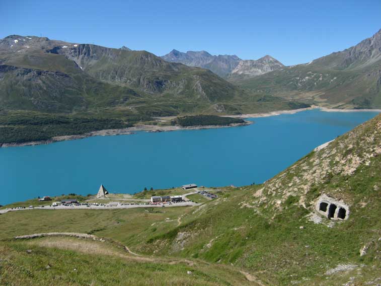Il Pian delle Fontanette sito del Ricovero F visto dai pressi del Ricovero Roncia.La strada attuale RN6 e tutti gli edifici presenti furono realizzati intorno al 1968 anno di ultimazione della diga dell'EDF.Precedentemente la strada passava in fondo all'attuale lago