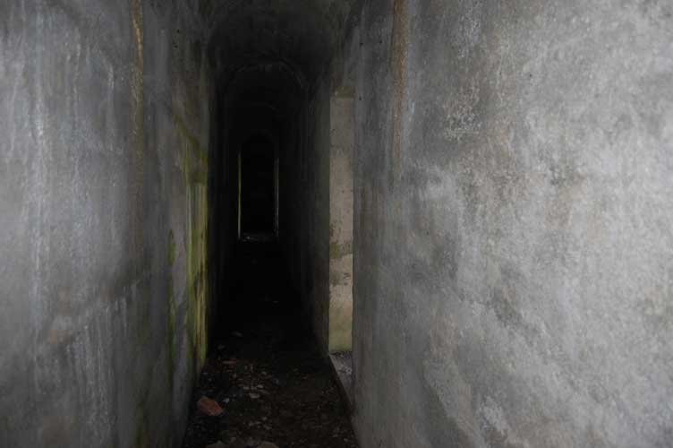 Il corridoio-intercapedine.A DX l'accesso alla casermetta e a SX il rivestimento della parete in roccia parete in roccia