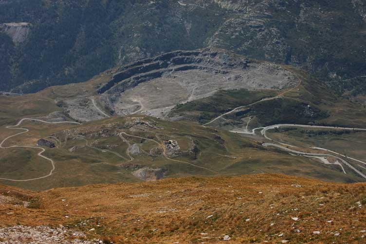 Uno sguardo in basso dal piazzaletto antistante il ricovero:possiamo notare l'enorme cratere provocato dall'estrazione del materiale necessario alla realizzazione della diga dell'EDF.Qui era ubicata la Batteria Paradiso di cui restano pochissimi resti.Possiamo inoltre notare il Ricovero del Passo delle Finestre e i ruderi della Batteria La Court