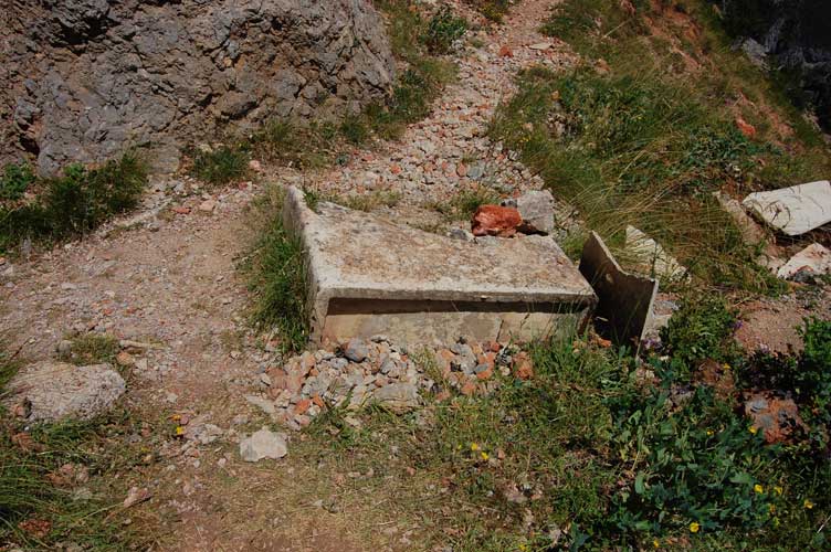 Di fronte all'ingresso i resti di un serbatoio in eternit per l'acqua