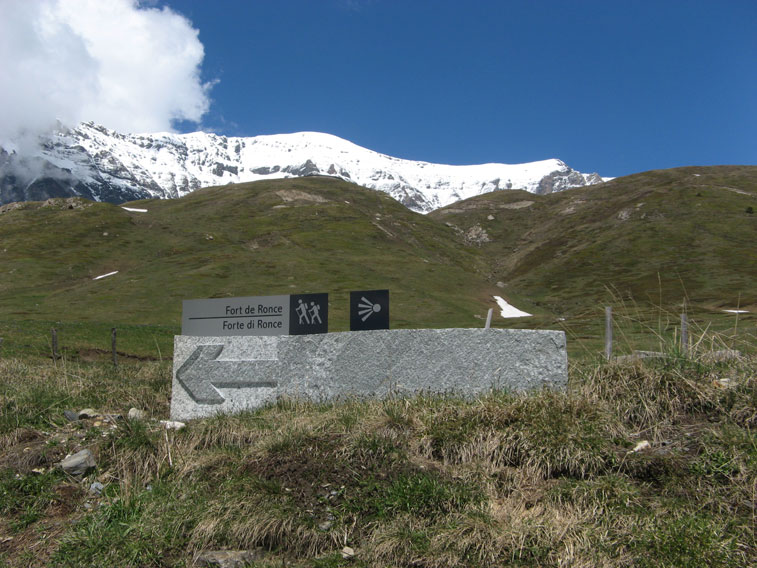 Un nuovo pannello installato al Pian delle Fontanette segnala la direzione per il Forte Roncia visibile in alto al centro e sopra di esso innevata Cima Roncia