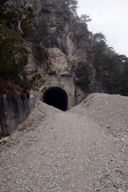 La strada ingombra di una frana di ghiaia prima della galleria
