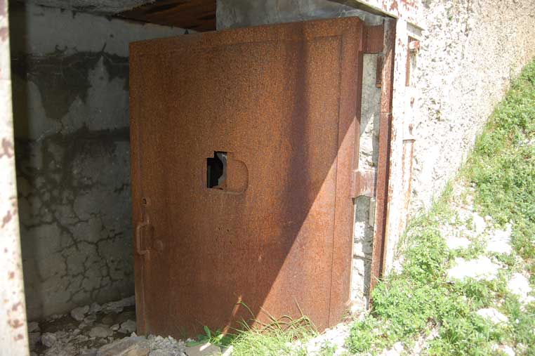 Particolare della porta di ingresso ormai bloccata in posizione semiaperta