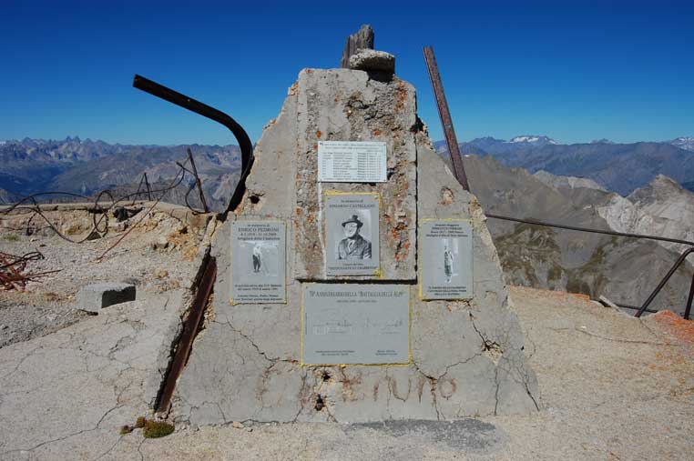 Il basamento del pennone della Bandiera con le targhe commemorative applicate in occasione della ricorrenza del 70° Anniversario della Battaglia delle Alpi