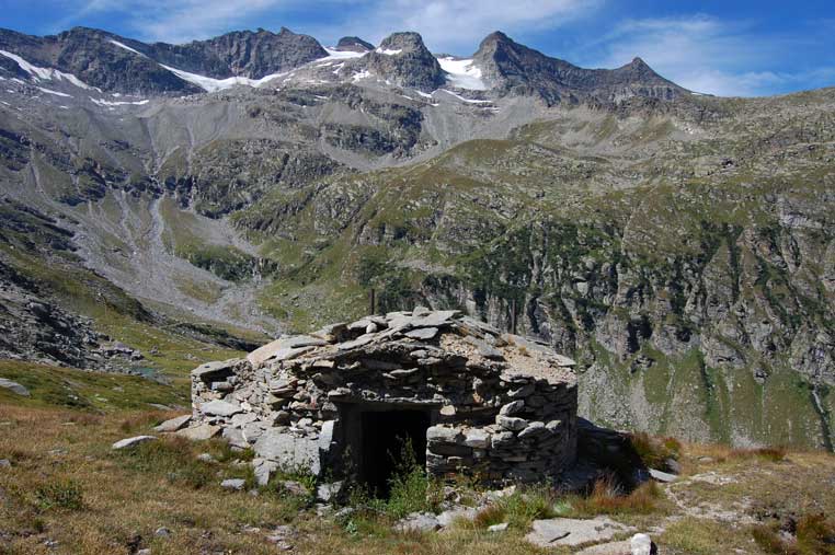 La facciata E con l'ingresso.Si intravede a sx il laghetto dell'Alpe Cernera e di fronte il ghiacciaio del Carro