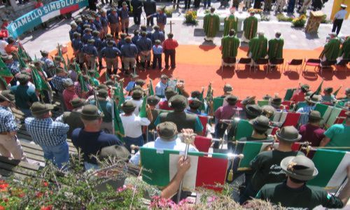 i Gagliardetti delle sezioni presenti. E il coro ANA Re di Castello di Daone  con la camicia blu a scacchi.