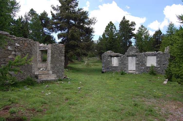 Appena sotto la cima i ruderi delle casermette,dietro a quella di dx inizia il breve tratto di sentiere che conduce all'ingresso della Batteria