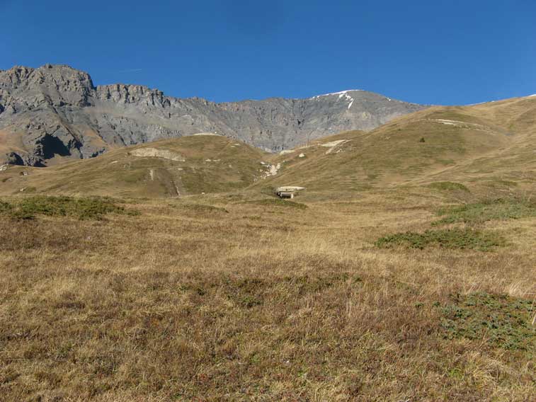 L'ingresso della postazione e in cima al rilievo erboso il Forte Roncia